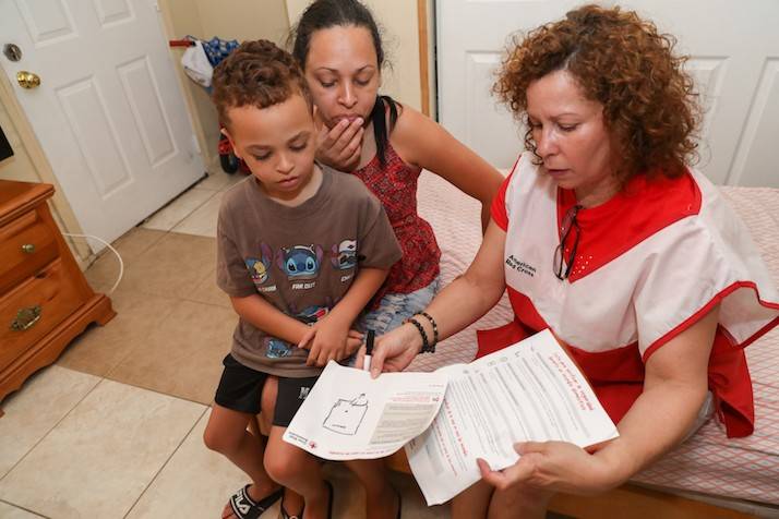 Volunteer reviews escape plan with woman and child